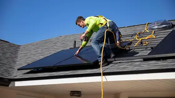 An installer fixing solar panels to a roof