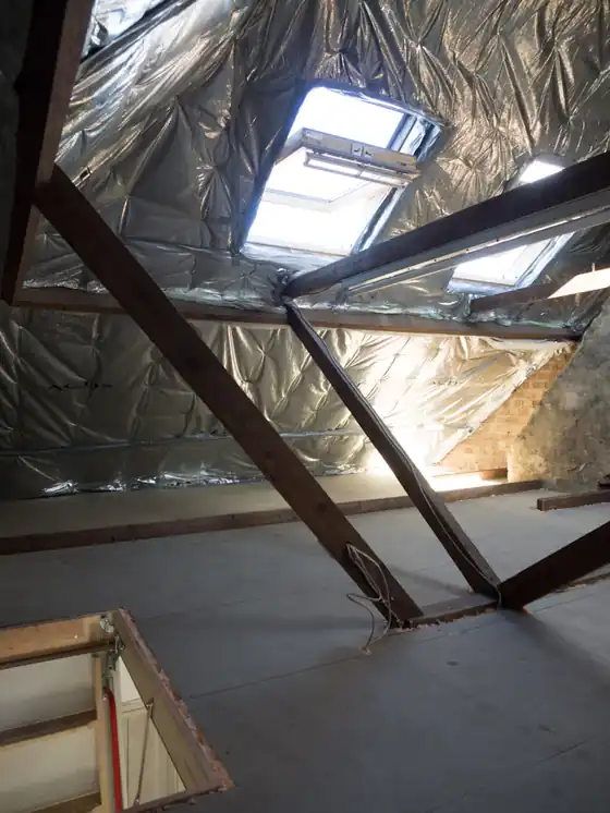 A loft lined with multi-foil insulation under two roof windows